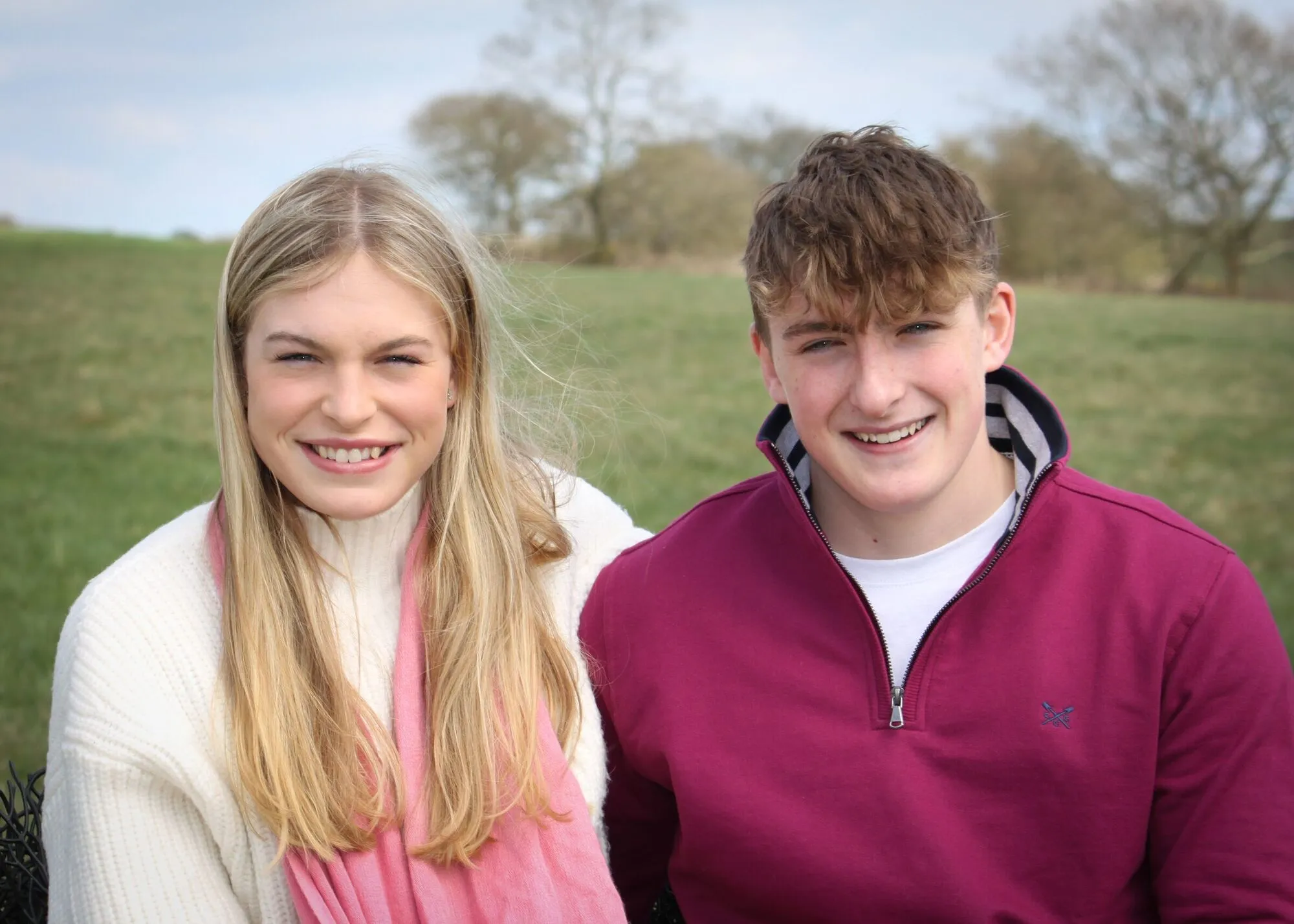 A smiling young woman and man photographed outdoors